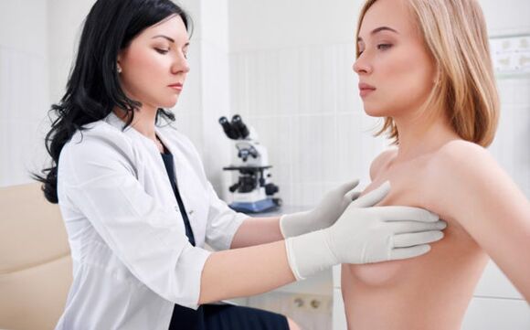 Examen realizado por un médico antes de la cirugía de aumento de senos.